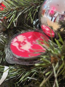 Smooth Reflection face primer by Genuist Beauty displayed in holiday greenery with a silver ornament reflecting the studio setting.