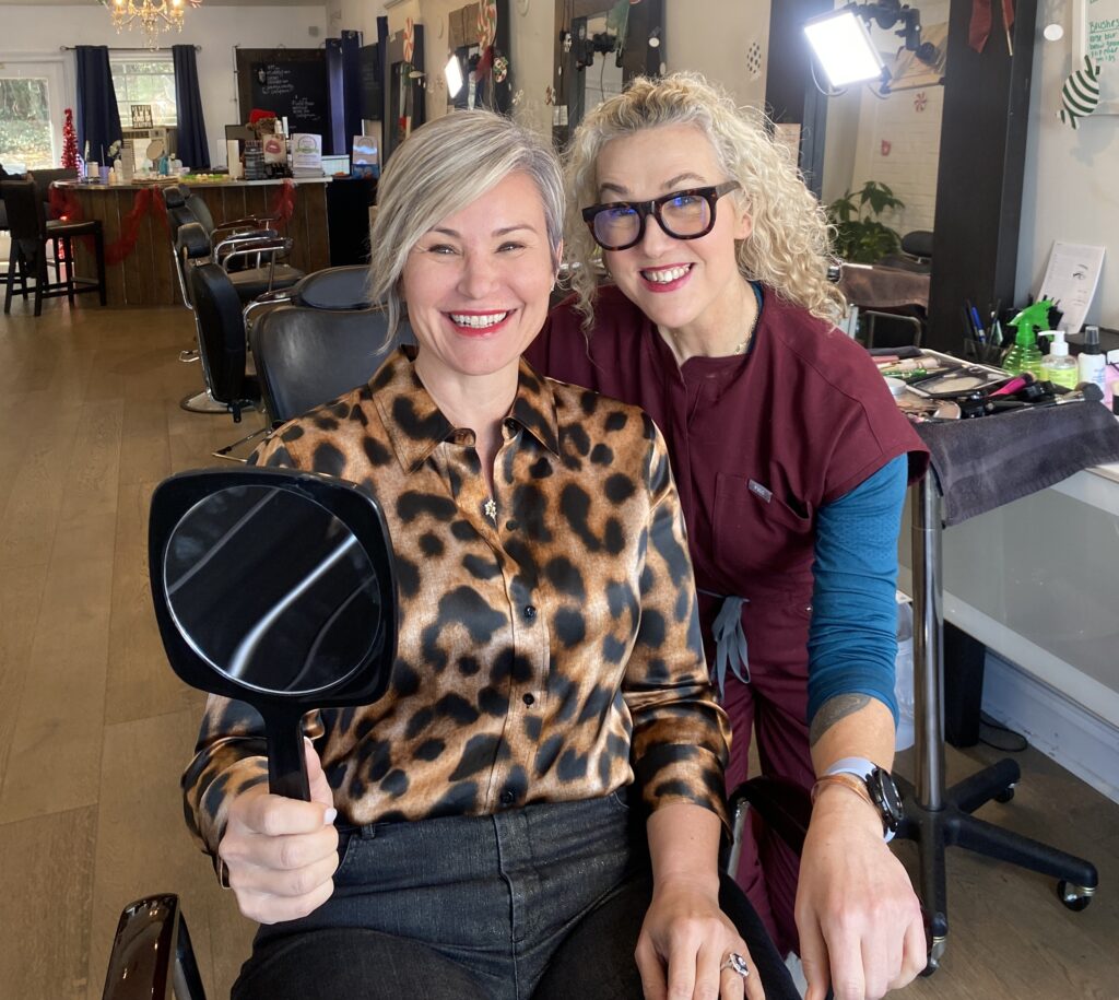 Alyson Hoag smiling with a makeup client during a personalized makeup lesson at Authentic Beauty Makeup Salon in Atlanta